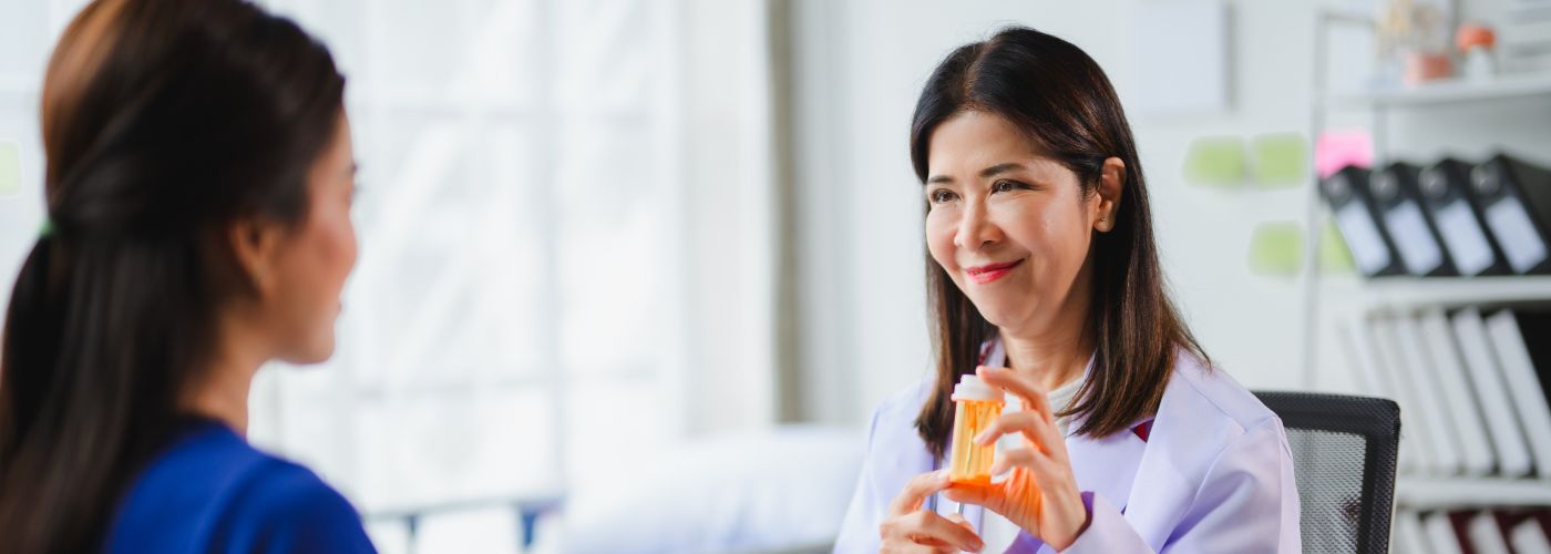 Doctor speaking with patient holding pill bottle